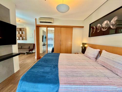 a bedroom with a large bed with a blue blanket at LFlats no Hotel Stella Vega (EX-Mercury Ibirapuera) in Sao Paulo