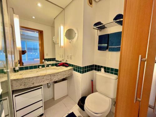 a bathroom with a toilet and a sink and a mirror at LFlats no Hotel Stella Vega (EX-Mercury Ibirapuera) in Sao Paulo