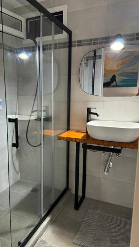 a bathroom with a sink and a shower at Vitorina Corte Guesthouse in Funchal