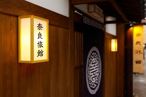 a sign on the side of a building with writing on it at Nara Ryokan in Nara