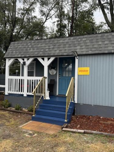 a small house with a blue door and stairs at Little Italy - Welcome to Venice Tiny House in Jacksonville