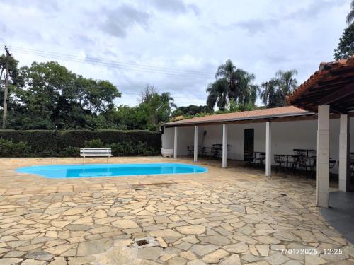 ein Schwimmbad in einem Hof neben einem Haus in der Unterkunft Chácara Serra Negra in Serra Negra