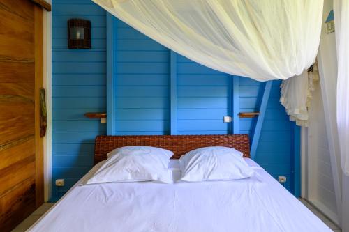 a blue bedroom with a bed with two pillows at Chez Marie & Philippe Ti'Kaz Cannelle in Cadet