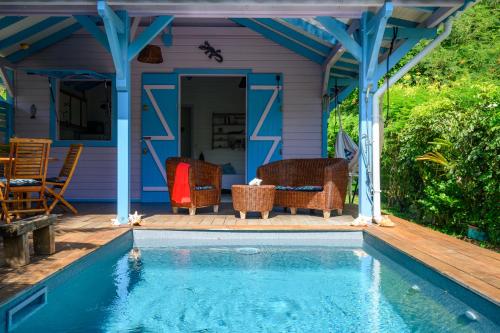 a house with a swimming pool on a wooden deck at Chez Marie & Philippe Ti'Kaz Cannelle in Cadet
