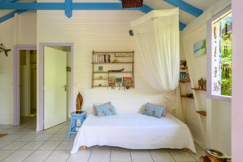 a bedroom with a white bed with blue accents at Chez Marie & Philippe Ti'Kaz Cannelle in Cadet