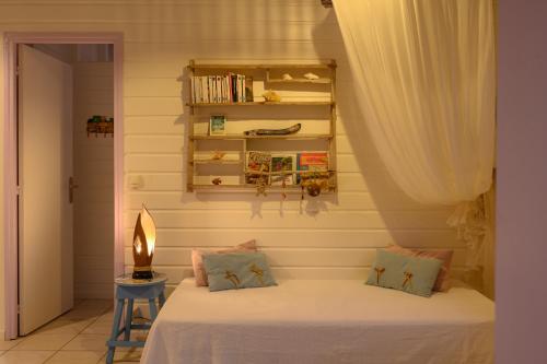 a bedroom with a bed and a book shelf at Chez Marie & Philippe Ti'Kaz Cannelle in Cadet