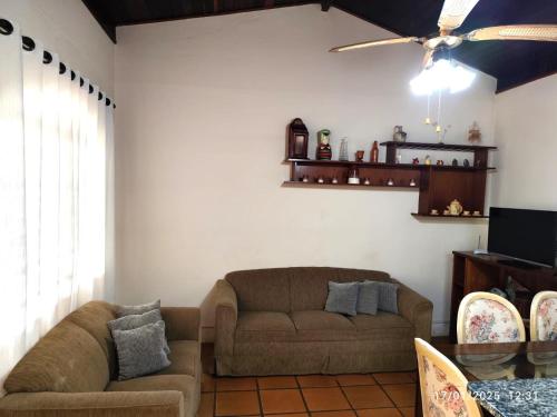 ein Wohnzimmer mit einer Couch und einem Deckenventilator in der Unterkunft Chácara Serra Negra in Serra Negra