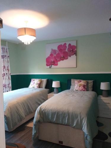 a bedroom with two beds and a painting of flowers at Bright cozy rooms in Meliden in Meliden