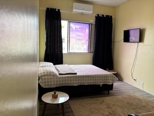 a small bedroom with a bed and a window at Vitrine Estadia in Rio de Janeiro