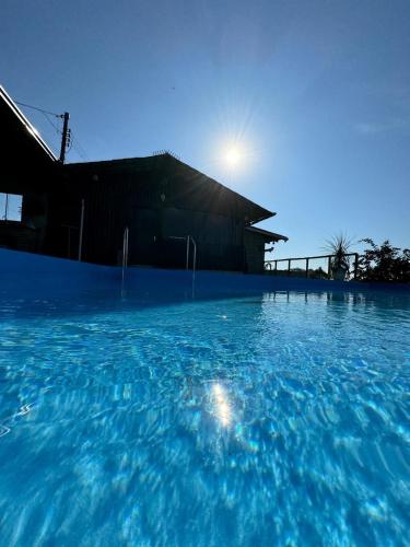 a large pool of blue water in front of a building at Casa de campo em Gaspar in Gaspar
