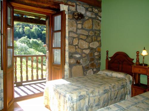 una camera da letto con un letto e un muro di pietra di Las Casucas de Ason ad Arredondo