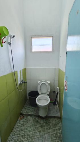 a small bathroom with a toilet and a window at Vila Anggur Pintukabun in Bukittinggi