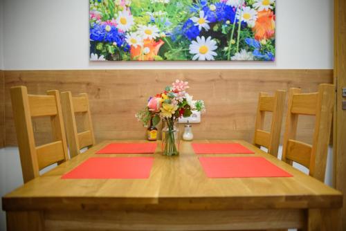 a wooden table with a vase of flowers on it at Apartmány Volavka 2 in Planá nad Lužnicí