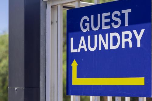 a blue sign that says guest laundry with a yellow arrow at Gosford Inn Motel in Gosford