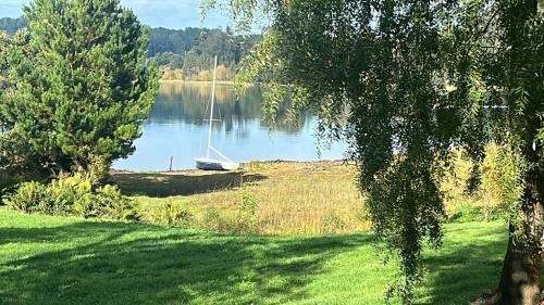 a boat sitting on the shore of a lake at La Casa Del Lago in Puerto Octay
