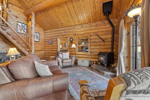 a living room with leather furniture in a log cabin at Whitetail Springs Ranch in Custer