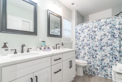 a bathroom with a sink and a toilet and a shower at King Beds Hot Tub Arcade Gas Grill Firepit Winston in Winston-Salem