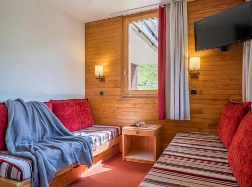 un salon avec un canapé et une fenêtre dans l'établissement Les Terrasses Blanches - Appartement Belle Plagne - 4 personnes - Exposition plein Sud - Sur pistes, à La Plagne Tarentaise