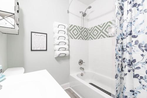 a bathroom with a shower curtain and a tub at King Beds Hot Tub Arcade Gas Grill Firepit Winston in Winston-Salem
