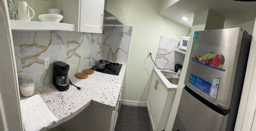 a small kitchen with a refrigerator and a counter at B01 cozy private room with bathroom in Mississauga