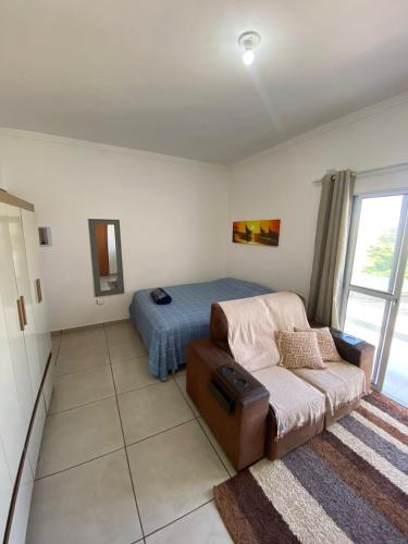 a living room with a couch and a bed at Lofts Rocha Setville in São José dos Campos
