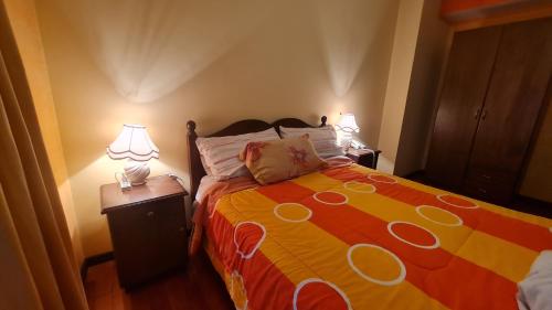 a bedroom with a bed and two lamps on a night stand at Hostal Montañes in La Paz