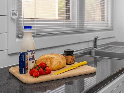 a cutting board with a loaf of bread and strawberries at Maison on Mair in Benalla
