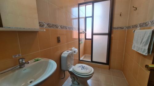a bathroom with a toilet and a sink and a tub at Hostal Montañes in La Paz