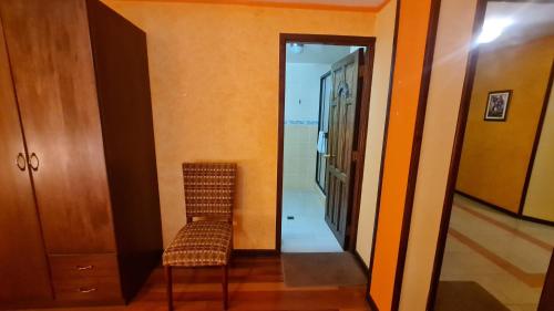 a hallway with a chair and a mirror at Hostal Montañes in La Paz