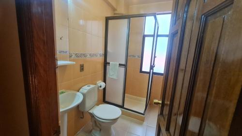 a bathroom with a toilet and a sink and a shower at Hostal Montañes in La Paz