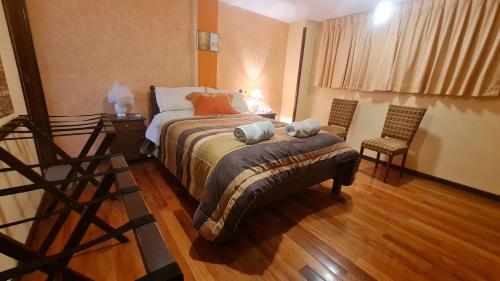 a hotel room with a bed and a chair at Hostal Montañes in La Paz
