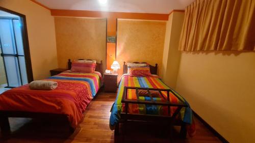 a bedroom with two beds and a cat laying on the bed at Hostal Montañes in La Paz