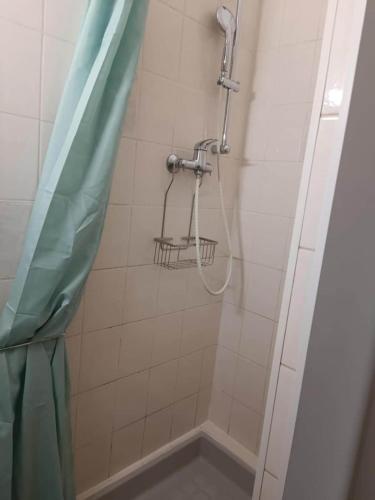 une douche avec un rideau de douche dans une salle de bain dans l'établissement Le calme à 2 pas du centre - F2 - 4 couchages, à Belfort