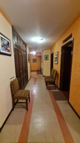 a hallway with two chairs and a hallway with at Hostal Montañes in La Paz