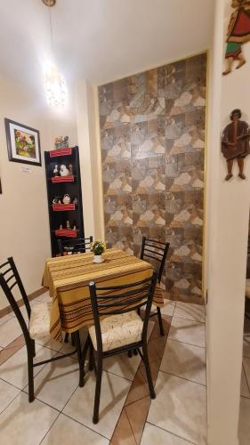 a dining room table and chairs with a stone wall at Hostal Montañes in La Paz