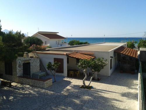 a white house with a view of the ocean at Appartamento Spiaggia Playa in Castellammare del Golfo