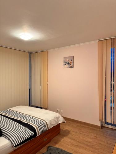 a bedroom with a bed and a painting on the wall at Home Guest - Apartment 1 in Oradea