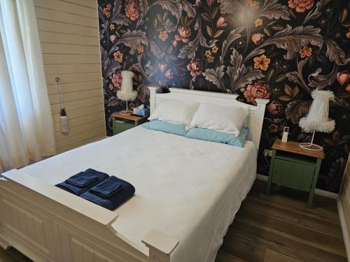 a bedroom with a large bed with a floral wallpaper at Taree CBD cottage apartments in Taree