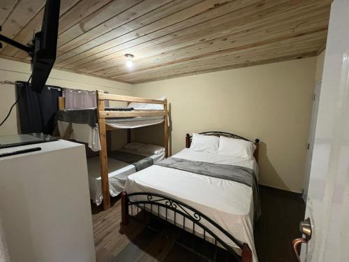 a small room with a bunk bed and a refrigerator at Vista Montaña Jimenoa De La Rosa in Jarabacoa