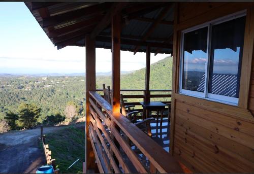 a porch of a cabin with a view of the mountains at Vista Montaña Jimenoa De La Rosa in Jarabacoa