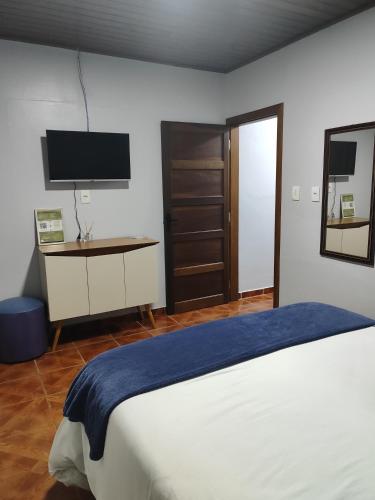 a bedroom with a bed and a tv on the wall at Residência Vô José - Casa 02 in Pomerode
