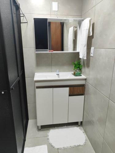 a bathroom with a white sink and a mirror at Residência Vô José - Casa 02 in Pomerode