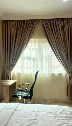 a bedroom with a chair in front of a window at House 27 in Abuja