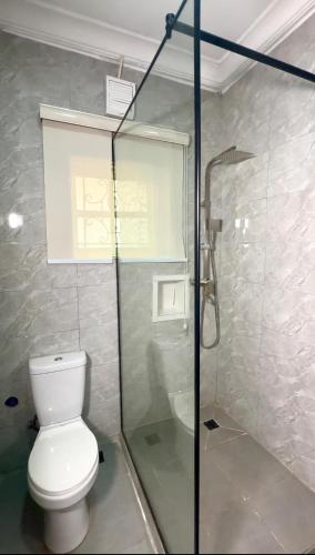 a bathroom with a toilet and a glass shower at House 27 in Abuja