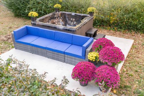 a blue couch and some pink flowers and a fire pit at Winston Ardmore Executive King Bed Suite &hot tub in Winston-Salem