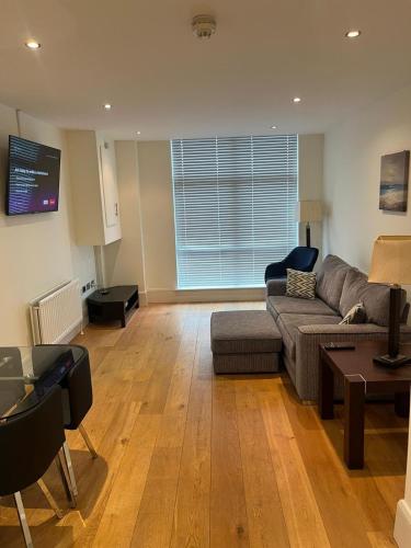 a living room with a couch and a table at Contemporary 1-Bed Apartment in The Bakery, Ormeau Road in Belfast