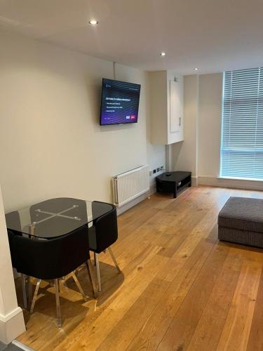 a living room with a glass table and a couch at Contemporary 1-Bed Apartment in The Bakery, Ormeau Road in Belfast
