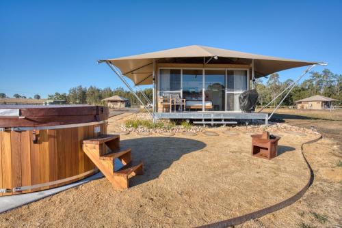 a house with a sauna and benches in a field at The Beltree Wine Country Glamping in Belford