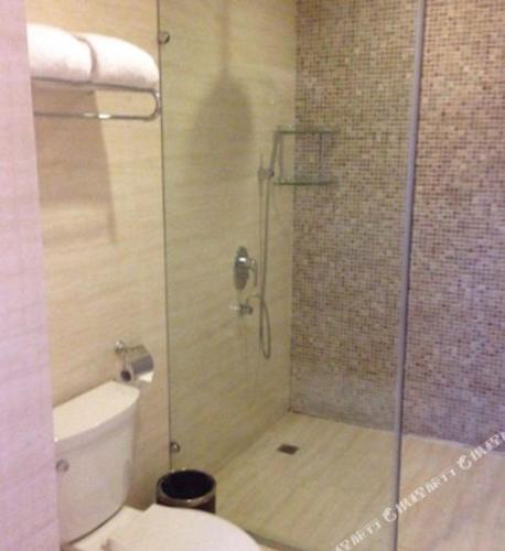 a bathroom with a glass shower with a toilet at The Qomolangma Hotel Beijing China in Beijing
