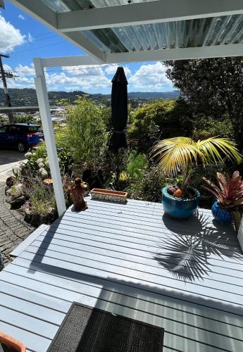 a deck with a umbrella and some plants on it at Unique city bungalow in Whangarei